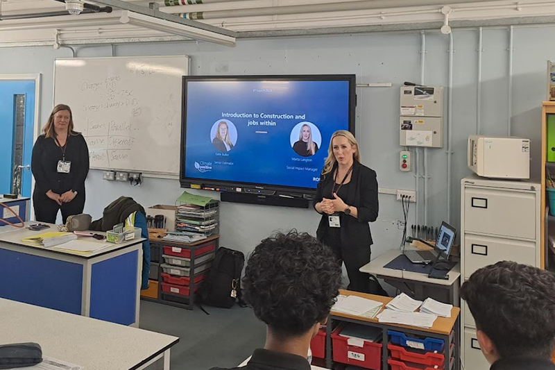 Two volunteers talking to a classroom