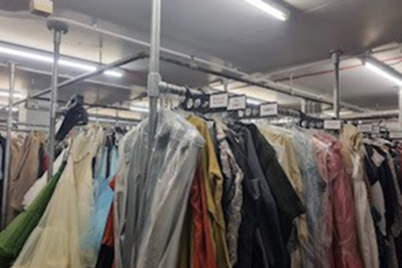 Suits hanging from some railings in a warehouse