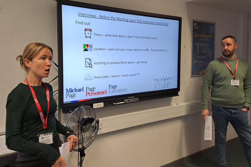 Two volunteers in front of a white board with interview tips