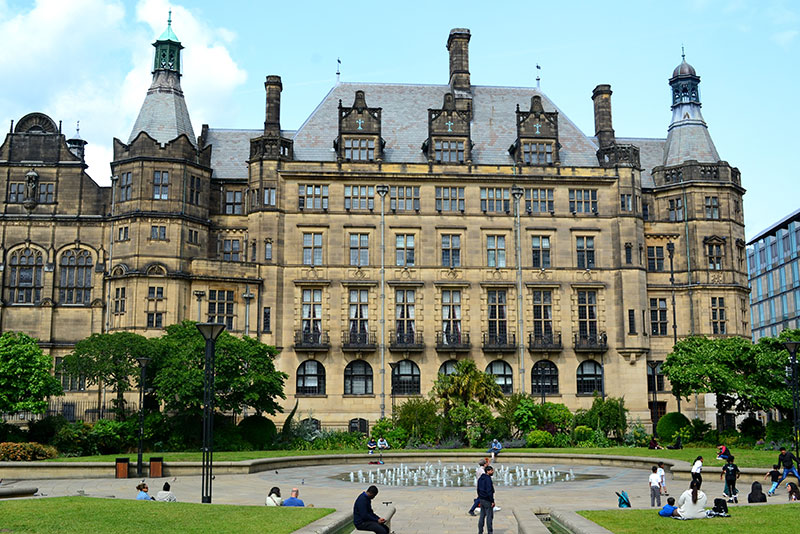 Facade of Sheffield Town Hall with greenery and fountain in front