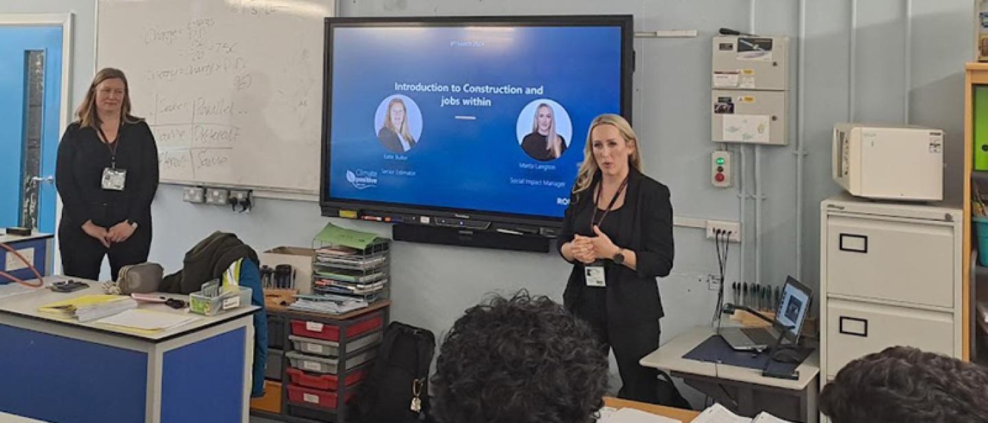 Two volunteers talking to a classroom